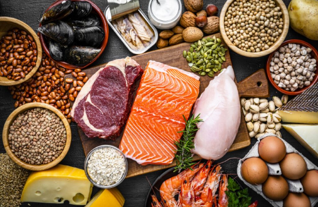 A selection of high protein foods including salmon, steak, chicken and eggs.